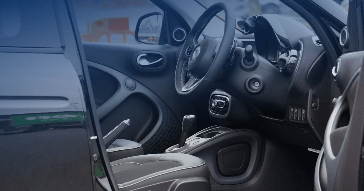 Interior of a vehicle with the driver door open, illustrating a New York charge for circumventing or tampering with an ignition interlock device.