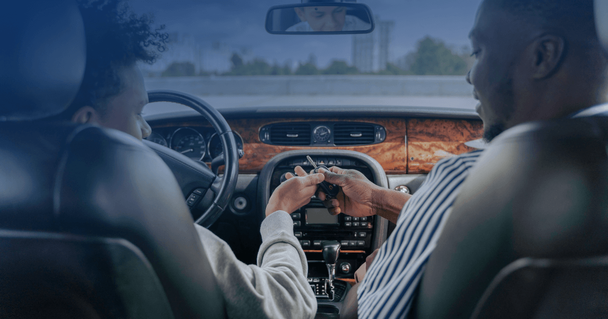 Two people inside a car exchanging keys, illustrating a New York charge for helping someone bypass an ignition interlock device.